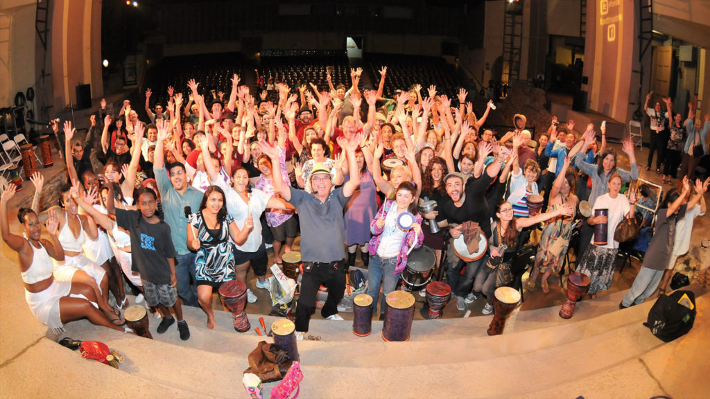 Group shot of people with hands in the air rejoicing after a wonderful drum session
